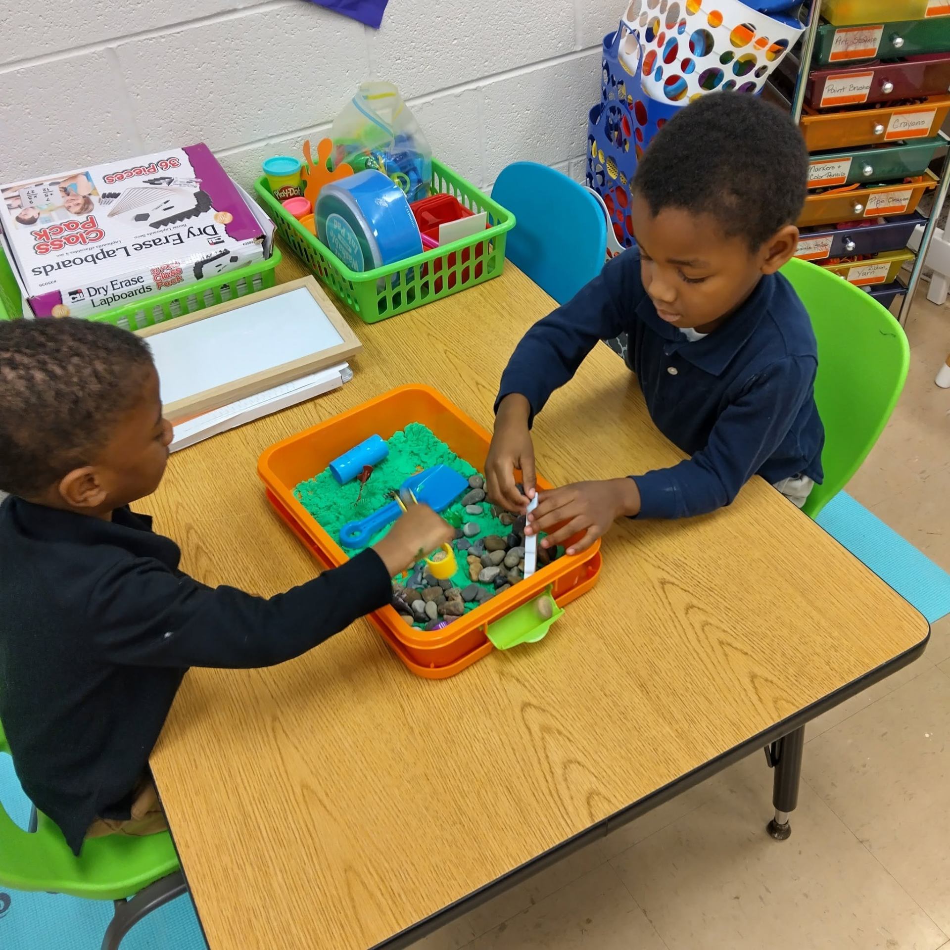 Two students exploring a sensory bin in the classroom