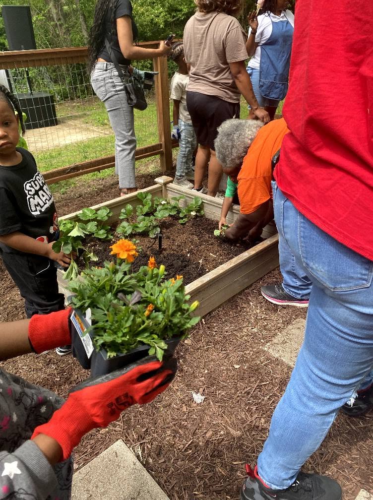 Children and families planting in the community garden