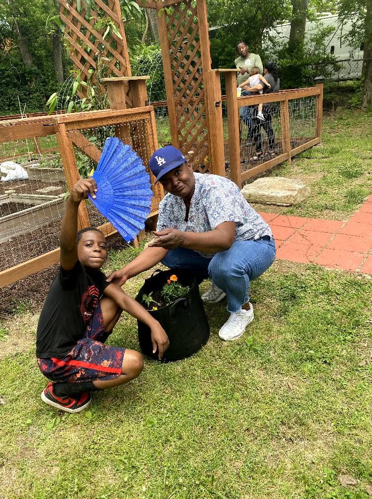 A young gardener and mentor planting marigolds together