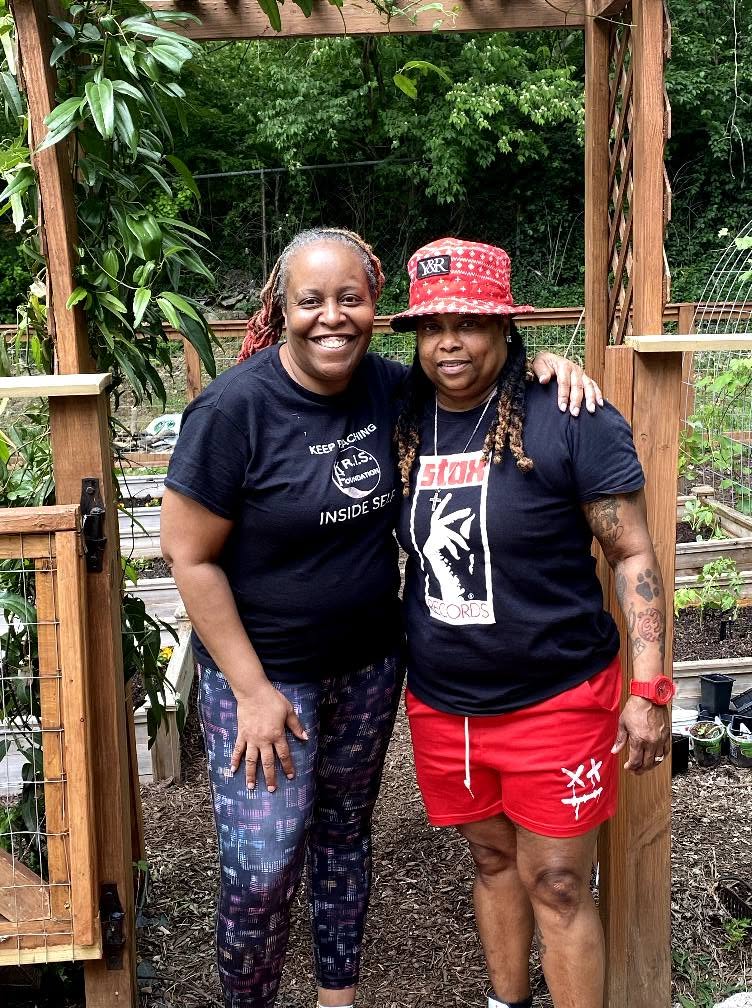 Two friends posing under the garden trellis