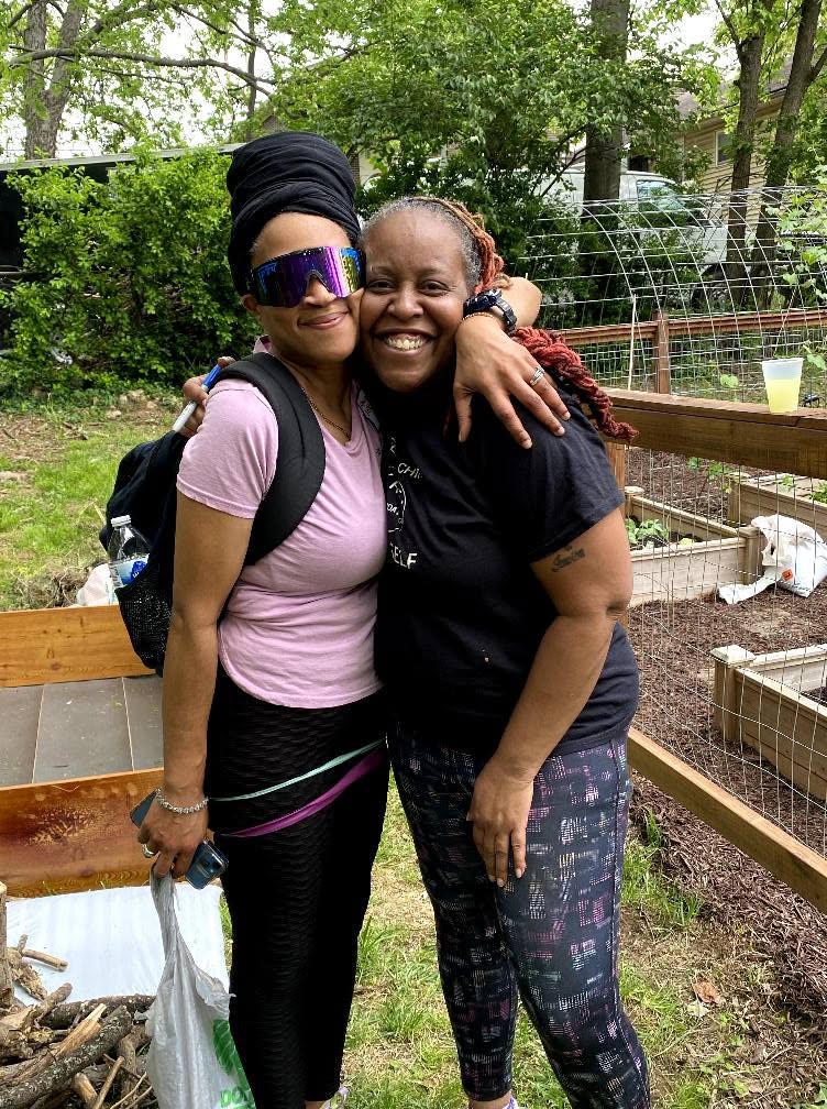 Two women sharing a hug in the community garden