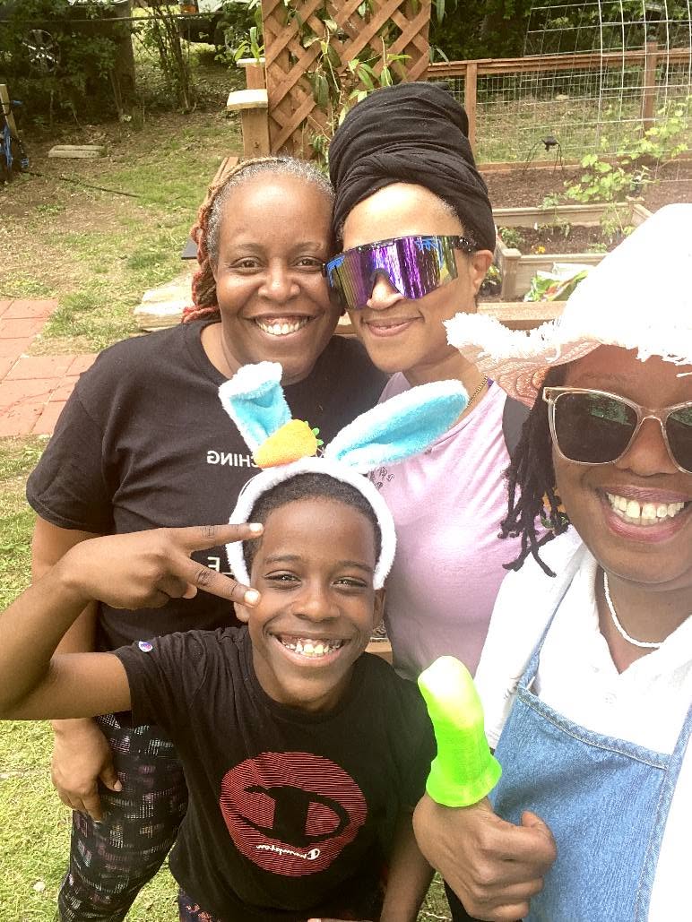 Shetika Davis with friends and a child in the community garden